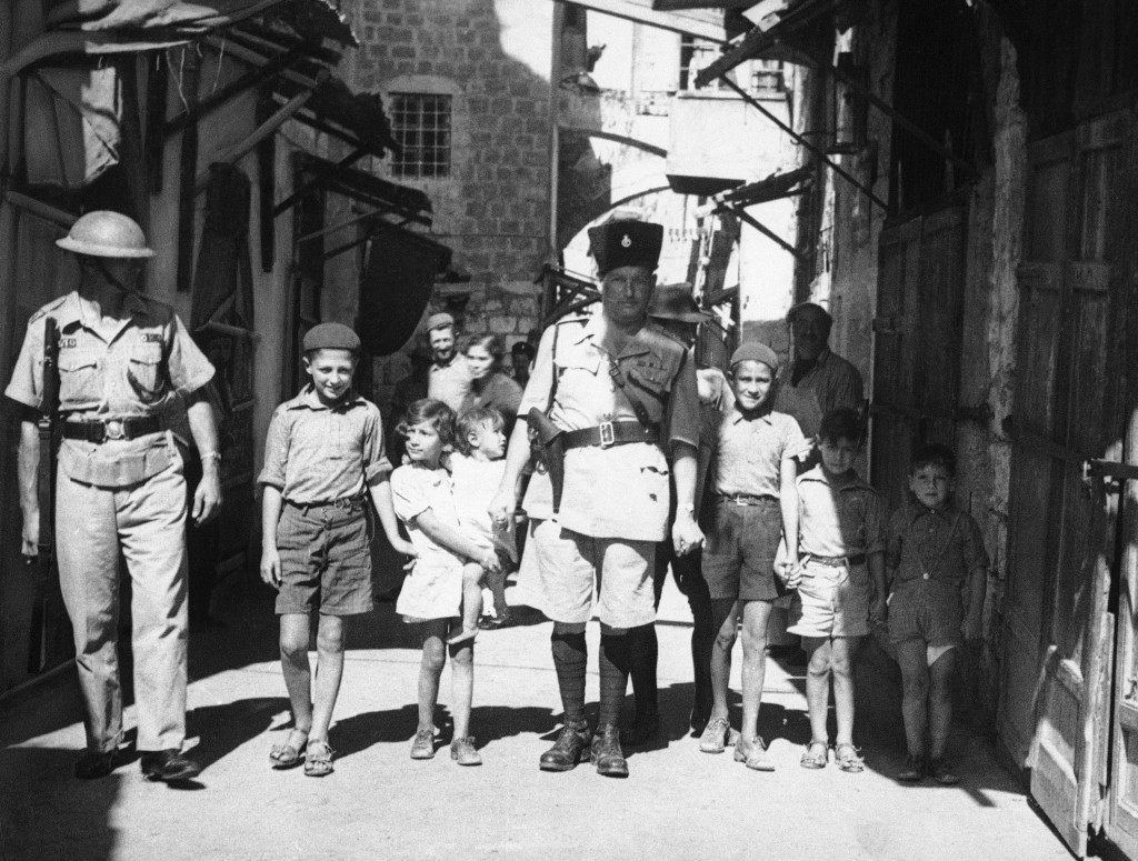 Since the British occupation of Jerusalem, Palestine, after the old city had been held for four days by Arabs, a measure of calm has descended on the district. Storm centre October 24ÂWhen this picture reached London by air after being was Jaffa, where there was sniping. British police captain leading Jewish kiddies to safety away from Arab snipers during the reoccupation of the old city of Jerusalem in Palestine, Israel on Oct. 24, 1938, by the British. (AP Photo/James Mills) Ref #: PA.8988895 Date: 24/10/1938 