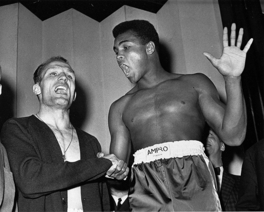  A June 18, 1963 photo from files showing world famous boxer Muhammad Ali (or Cassius Clay as he was then known), right, and British heavyweight champion Henry Cooper as they seem to be trying to out shout each other at weigh-in in London for their heavyweight fight the same evening. Ali holds up five fingers, the number of rounds he modestly predicts he'll knockout Cooper