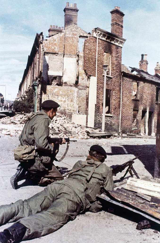 Against a background of ruined homes, British troops guard a strategic roadway position in their peacekeeping role in Belfast, Northern Ireland in 1969. (AP Photo/Peter Kemp) Ref #: PA.11408232 