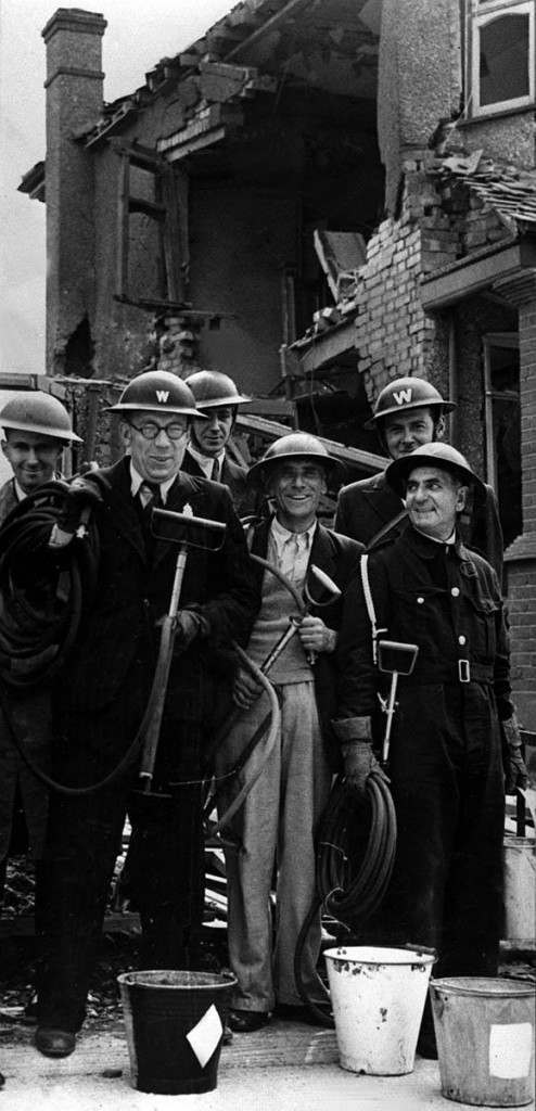 AIR RAID WARDENS 1940: Members of a team of Air Raid Wardens in a London suburb who have been tackling and extinguishing Luftwaffe incendiary bombs. The men are holding stirrup pumps, used to douse fires with water from a bucket. Picture part of PA Second World War Collection : The Blitz