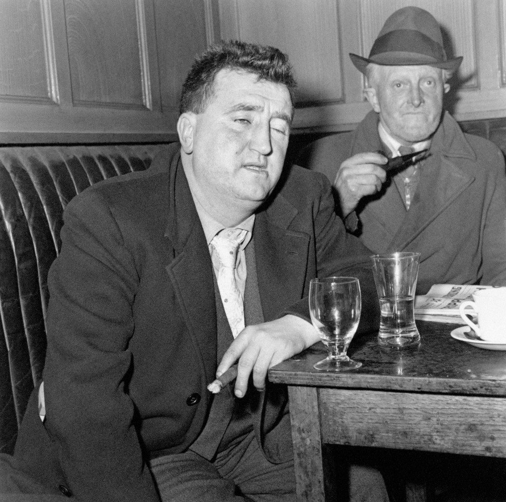 Irish playwright Brendan Behan, whose plays "The Quare Fellow" and "The Hostage" were enthusiastically received in London's West End, enjoys a drink and a chat with his friend Michael Collins in Tom Moore's Bar in Dublin, Ireland. Picture date:February 9, 1961. Ref #: PA.2414430 