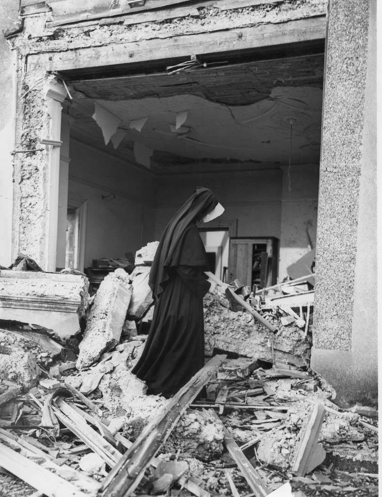 A nun at a convent school in the home counties inspects the damage done to one of the classrooms after a Nazi bomb hit the school during a night raid in London, March 21, 1941. Five nuns were injured during the bombing. (AP Photo)