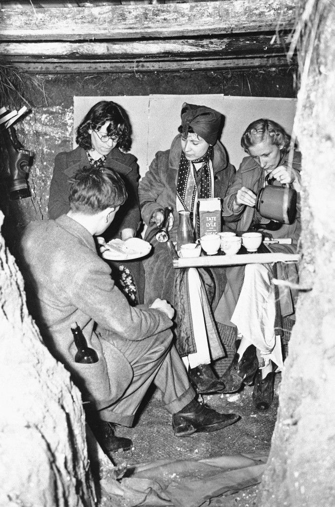 This is typical of the way Londoners had breakfast in England, Sept. 6, 1939, after the air raid warning had sounded. Breakfast was in the family dugout--this one in a garden?with a gasmask hanging ready. (AP Photo)