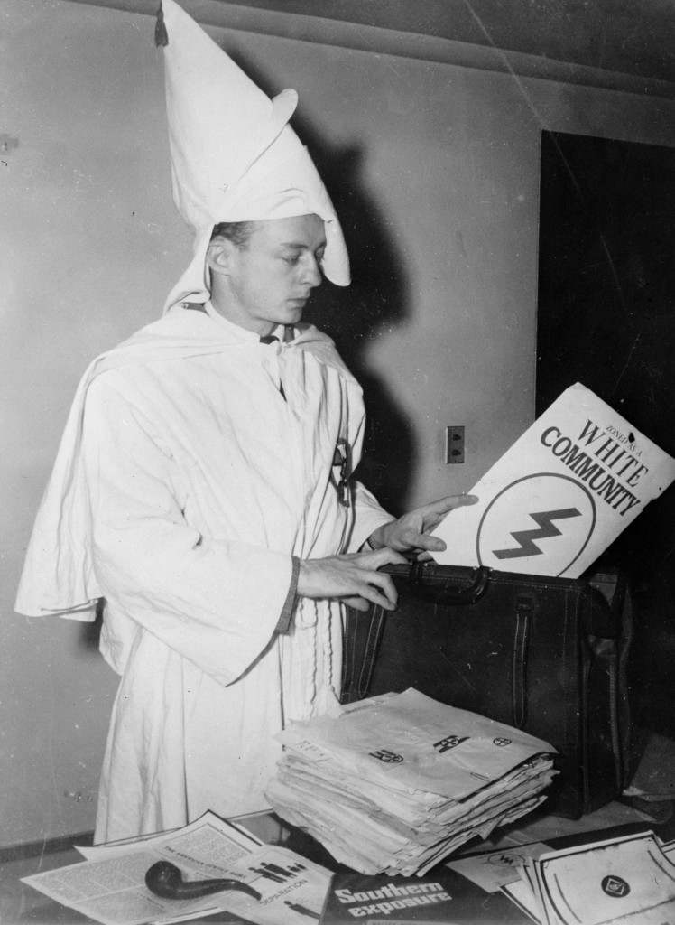 February 1947:  Stetson Kennedy, author of the Ku Klux Klan study 'Southern Exposure', posing in the Klan's uniform to illustrate the sign of the cross made before the altar at KKK meetings.  (Photo by Keystone Features/Getty Images)