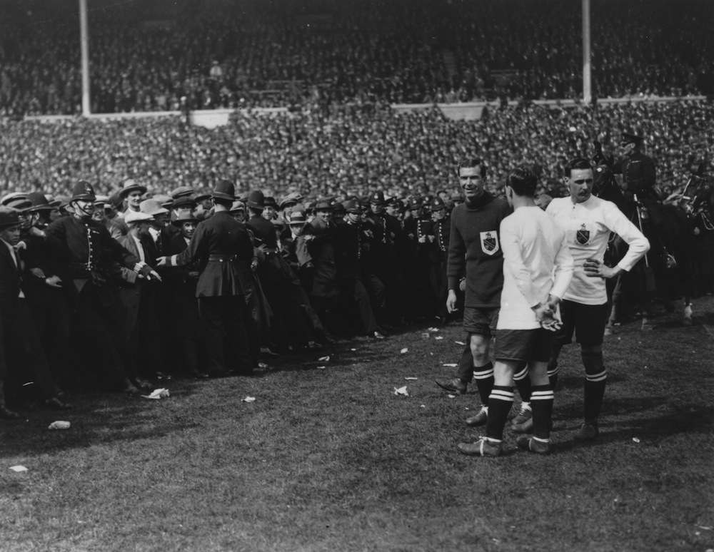 28 APR 1923:  POLICE ATTEMPT TO KEEP THE CROWDS OFF THE PITCH BEFORE THE START OF THE FIRST F.A. CUP FINAL TO BE PLAYED AT WEMBLEY STADIUM.  THE MATCH BETWEEN WEST HAM UNITED AND BOLTON WANDERERS ATTRACTED AN ESTIMATED 200,000 PEOPLE.  BOLTON WON 2-0. Mandatory Credit: Allsport Hulton/Archive
