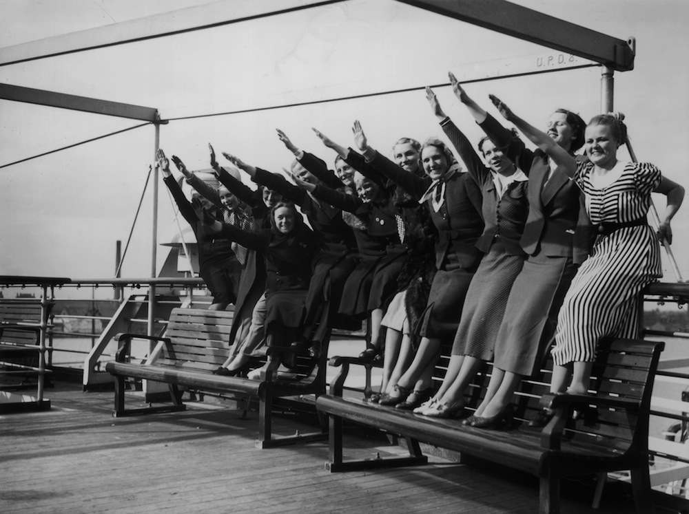 A group of women give the Nazi salute on the deck of the Wilhelm Gustloff at Tilbury, 10th April 1938. The ship is a floating polling station enabling the 2,500 German citizens resident in Britain to vote in Nazi Germany's 1938 plebiscite. (Photo by Becker/Fox Photos/Hulton Archive/Getty Images)