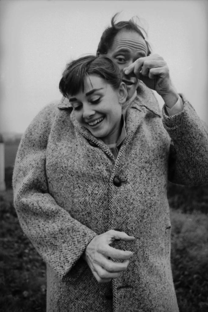 American actor Mel Ferrer (1917 - 2008) buttons up his coat around his wife, actress Audrey Hepburn (1929-1993), on a country road outside Paris, 1956. (Photo by Ed Feingersh/Michael Ochs Archives/Getty Images)
