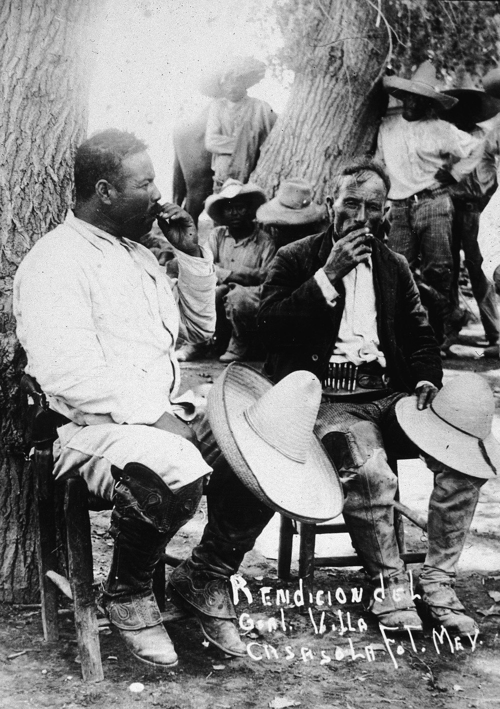 Mexican revolutionary leader Pancho Villa (1878 - 1923) (L)  sits against a tree with a fellow soldier, their straw hats over their knees, following the Mexican Revolution of 1911. (Photo by Hulton Archive/Getty Images)