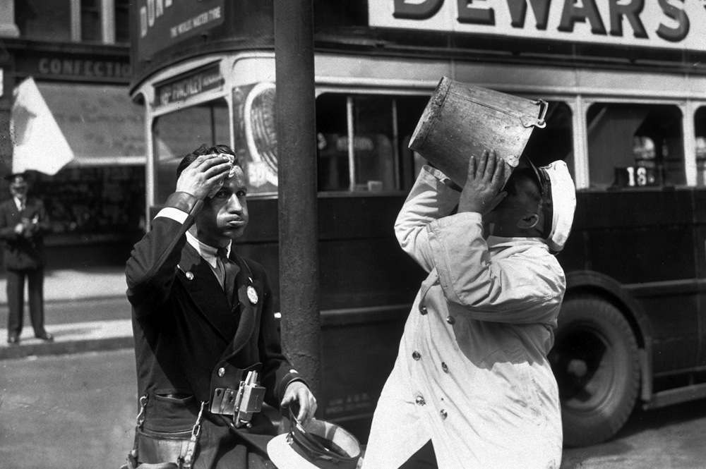 circa 1935:  A bus driver and conductor stop for a water break during a heatwave in London.  (Photo by Topical Press Agency/Getty Images)