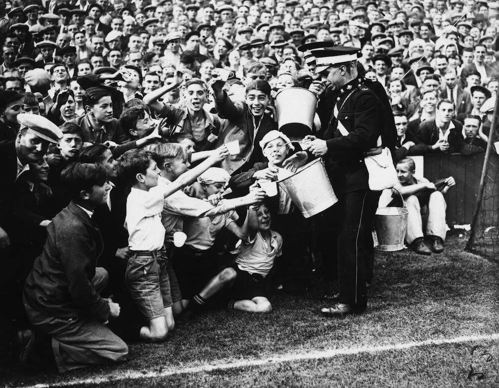 29th August 1936:  St John's Ambulancemen handing out oatmeal drinks in the heat at the football match between West Ham United and Tottenham Hotspur at Upton Park.  (Photo by E. Dean/Topical Press Agency/Getty Images)