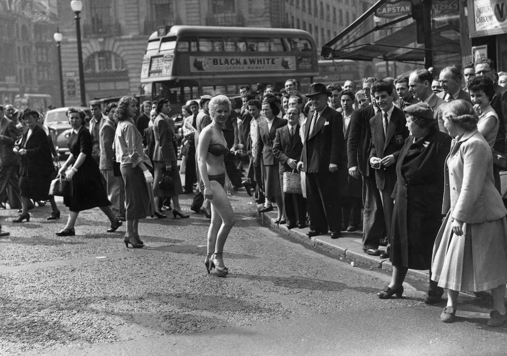 19th April 1952:  19 year old usherette Margaret Lewis from Carmaethen, Wales, who lives in Kensington, caused a stir in Piccadilly when she decided to beat the heat wave and travel to work clad only in bikini and high heels.  (Photo by Reg Speller/Fox Photos/Getty Images)