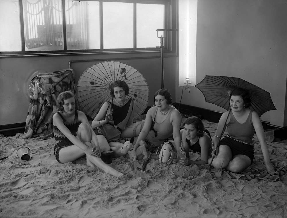 1st March 1930: A group of ladies relax on the sandy floor in the solarium of the Tolland Hotel, Bournemouth. (Photo by Fox Photos/Getty Images)