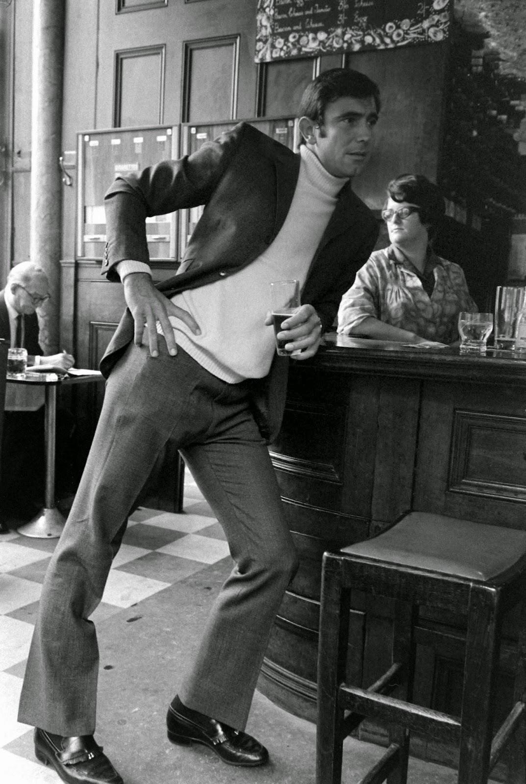 George Lazenby leans against a bar during a moment away from James Bond auditions, 1967.