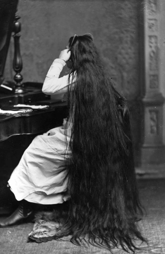 circa 1890:  Miss Milo combs her very long hair.  (Photo by Hulton Archive/Getty Images)