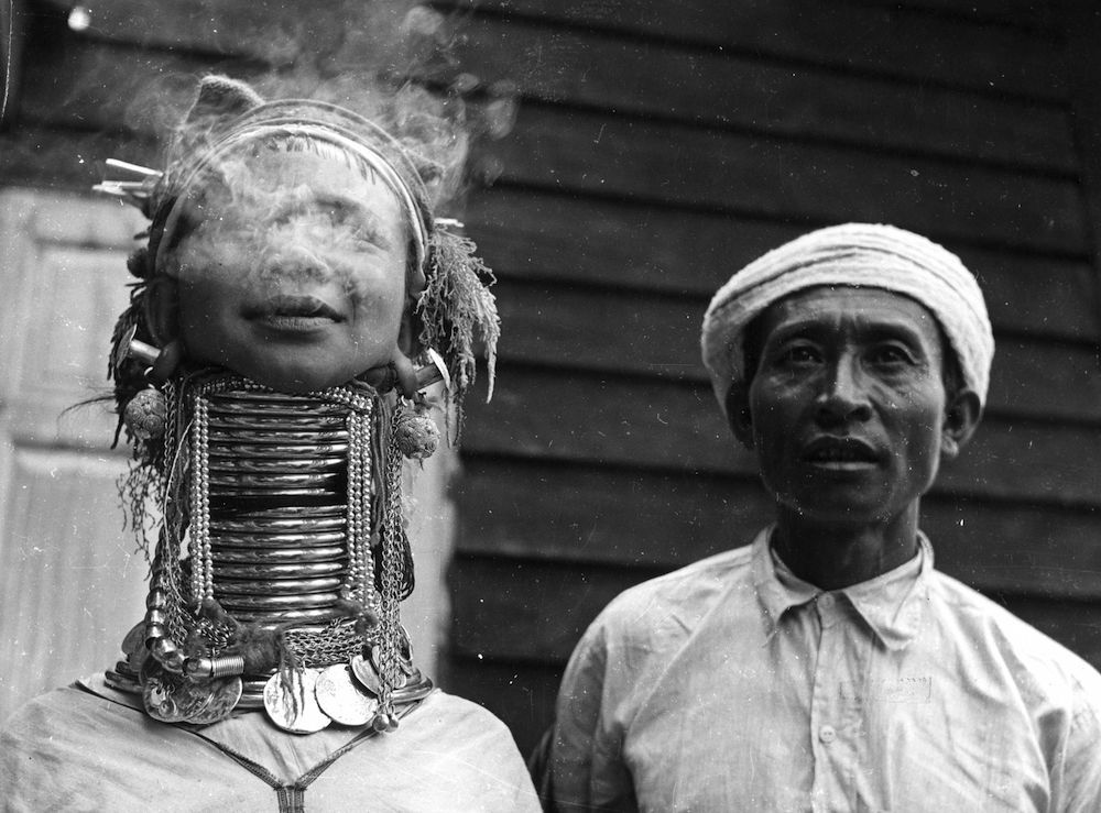 circa 1955:  A Padaung, or Kayan, woman exhales smoke. Originally a Mongolian tribe, the Padaung have been assimilated into the Karen group native to Mayanmar (Burma). A stiking feature of Padaung culture is the fitting of brass rings to the necks and limbs of women born on Wednesdays. From the age of five or six, successive rings are fitted every two years, denoting the status of their family.  (Photo by Three Lions/Getty Images)