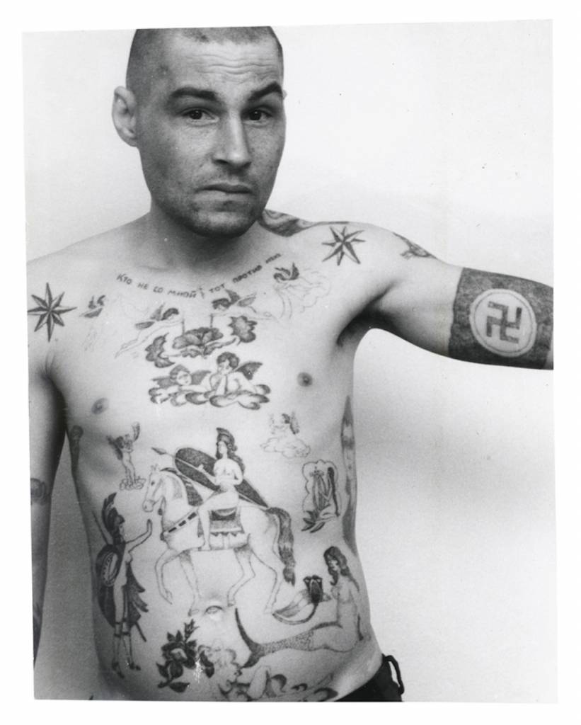 Text across the chest reads ‘He who is not with me is against me’. The swastika and Nazi symbols may mean that the owner has fascist sympathies, though they are more usually made as a protest and display of aggression  towards the prison or camp administration. During the Soviet period the authorities often removed these tattoos by force either surgically or by using an etching method. A tattoo of a mermaid can indicate a sentence for rape of a minor, or child molestation. In prison jargon the nickname for a person who commits this type of crime is amurik meaning ‘cupid’, lohmatii ‘shaggy’, or a universal ‘all rounder’. They are ‘lowered’ in status by being forcibly sodomised by other prisoners, sometimes in groups.  © Arkady Bronnikov / FUEL 