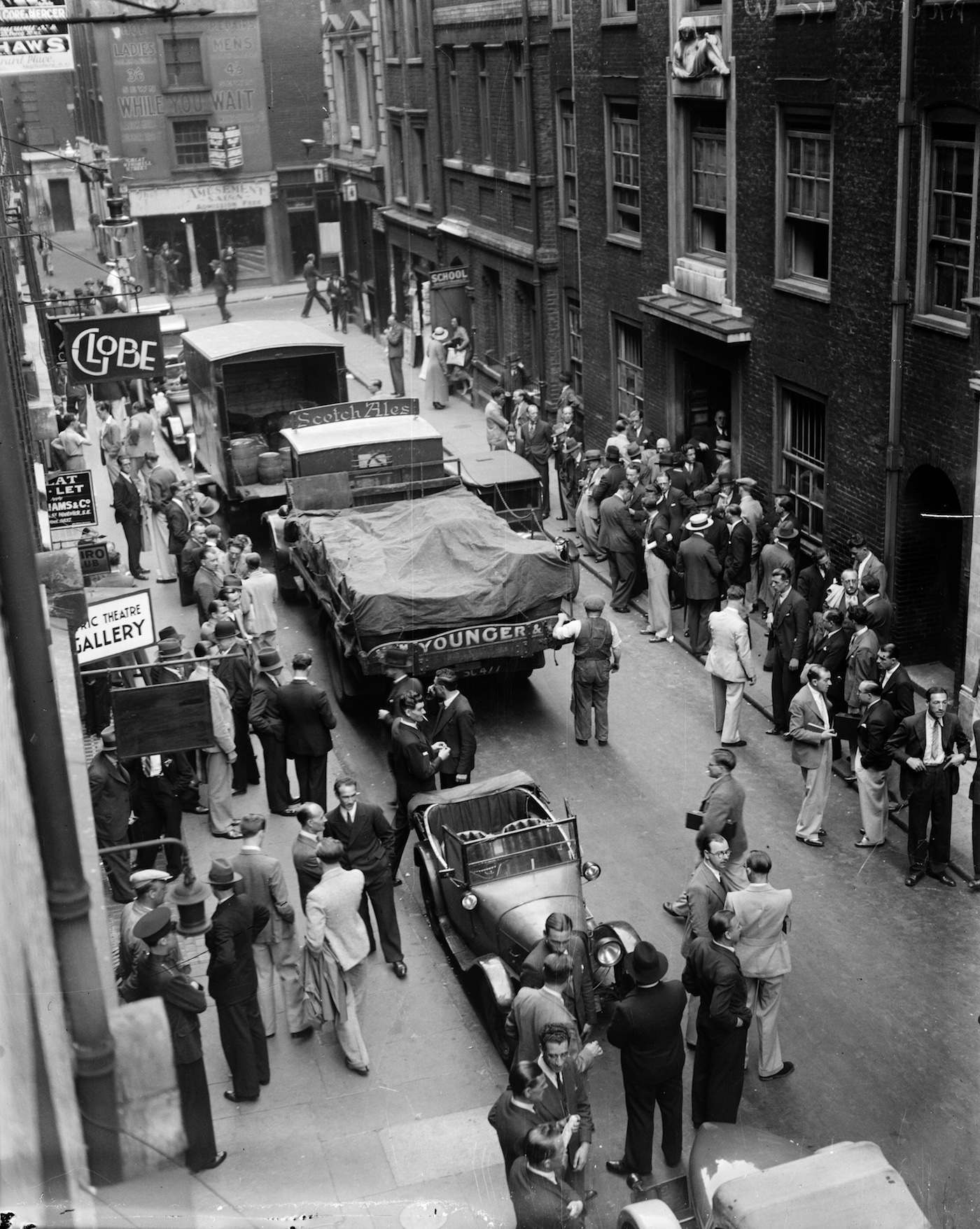 1935:  In Archer St, Soho, London musicians gather in groups waiting to see if there is any work available.  (Photo by General Photographic Agency/Getty Images)