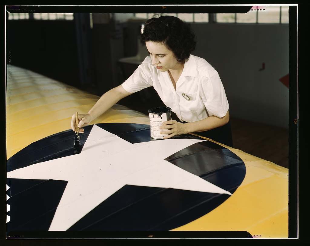 Women from all fields have joined the production army, Corpus Christi, Texas. Miss Grace Weaver, a civil service worker at the Naval Air Base, and a school teacher before the war, is doing her part for victory along with her brother who is a flying instructor in the Army. Miss Weaver paints the American insignia on repaired Navy plane wings
