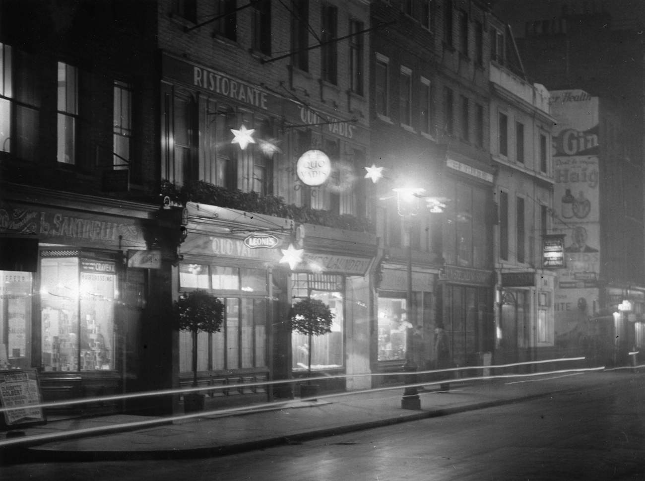 circa 1935:  Dean St, Soho at night showing the outside of the Quo Vadis restaurant.  (Photo by Hulton Archive/Getty Images)