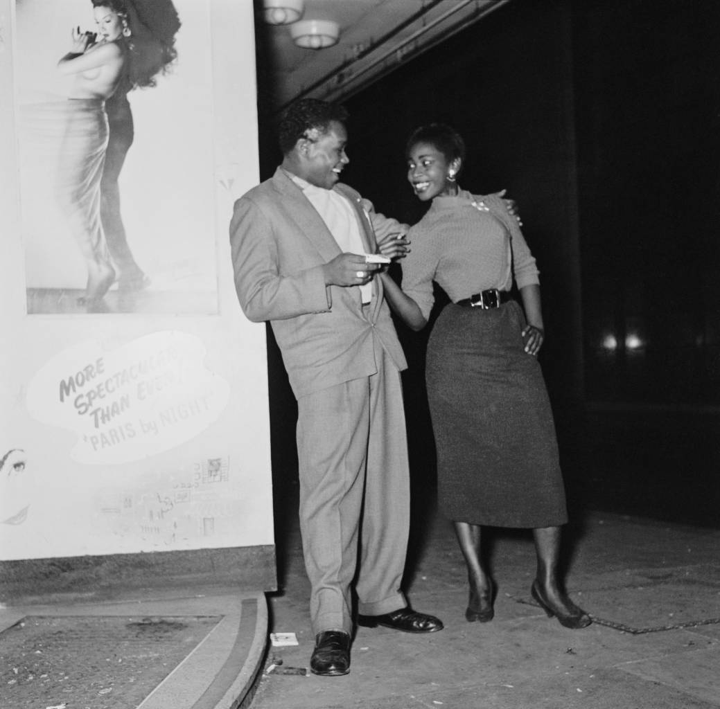 A young couple pose outside the 'Club Americana', a Saturday night jazz club open from midnight until 7 a.m., London, 25th November 1955. (Photo by Keystone Features/Hulton Archive/Getty Images)