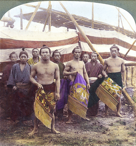 8 1/2 SUMO WRESTLERS with CEREMONIAL GARB (Or, How Come They Ain't FAT ?)  A beautiful, hand-colored stereo-photo by T. Enami, ca.1898-1905.   View number S-363 from Enami's 3-D Catalog.   ♥ LARGE SIZE --- HIT THIS LINK to enjoy the richness of the image :   www.flickr.com/photos/24443965@N08/2327829579/sizes/o/in/...   NOTE : This image is FREE TO DOWNLOAD and RE-BLOG, along with all the rest of my old photo collection posted here. Thanks in advance for proper collection credit and links.   *   8 1/2 men ? Yup. The guy on the very left moved his head around just a bit during the relatively slow exposure. His head is transparent --- through his chin and mouth --- against the large white stripe, but his body is solid against the lower red stripe.   In Japanese ghost lore, it is usually the BOTTOM half that fades out, with the head being solid. Leave it to the the Sumo guys to come up with a new take on the old "Shinrei Shashin", or "Ghost Photo".