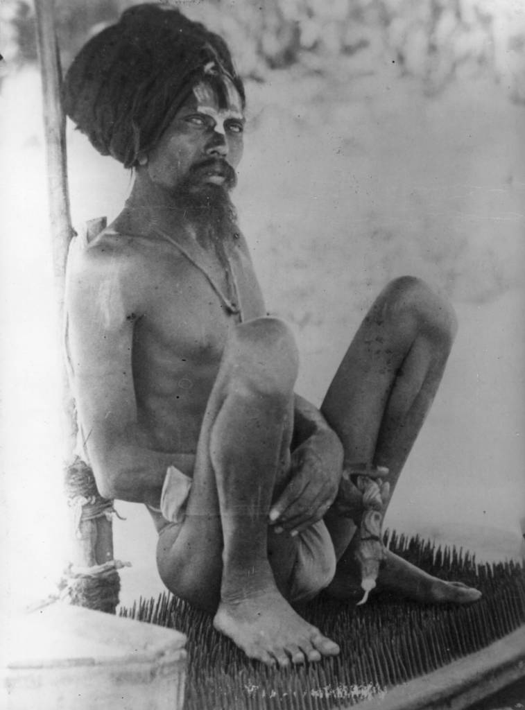circa 1920: Dr Johra Bey, a Muslim fakir, lying on a bed of nails. (Photo by General Photographic Agency/Getty Images)