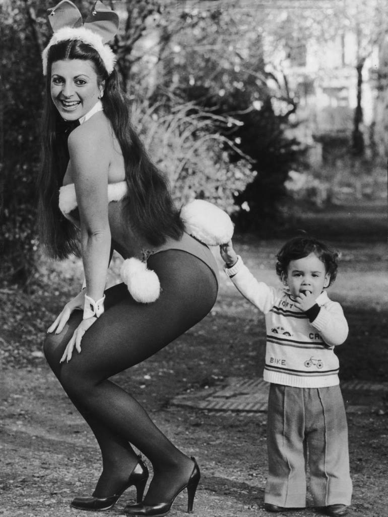 1979: Two-year-old Susie Paz strokes the tale of Playboy Club bunny girl Genevieve Allenbury. Genevieve is about to take part in a sponsored swim to raise money for the Child Development Centre at the West London Hospital. (Photo by Stuart Nicol/Evening Standard/Getty Images)