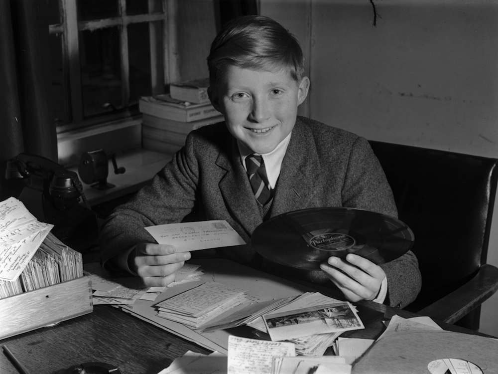 Twelve year old David Dimbleby, son of BBC commentator Richard, with a requested record for the 'Family Favourites' radio programme that he will present on Boxing Day. (Photo by William Vanderson/Getty Images)