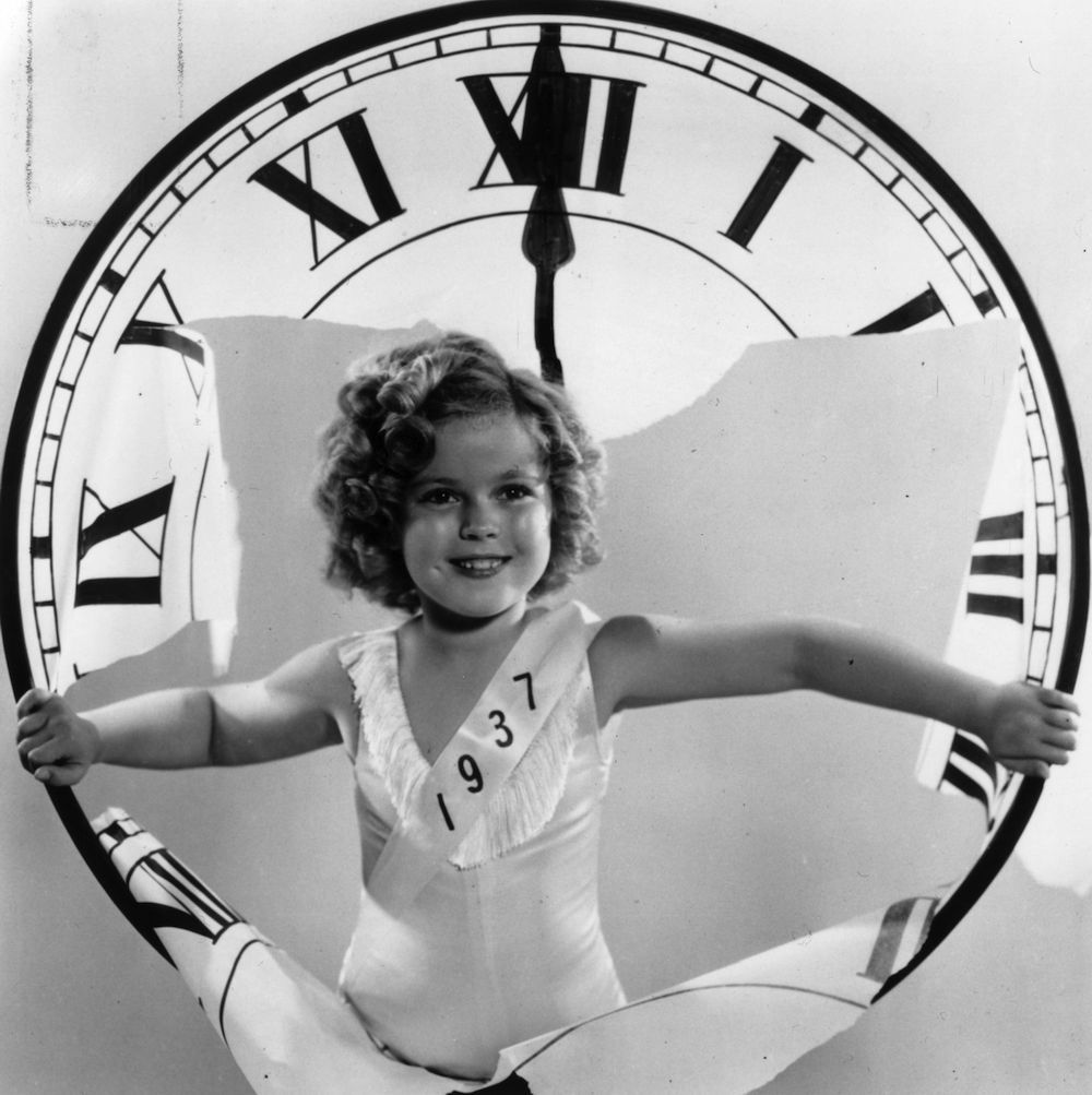 26th December 1936: American child star Shirley Temple celebrating the arrival of a new year. (Photo by Fox Photos/Getty Images)