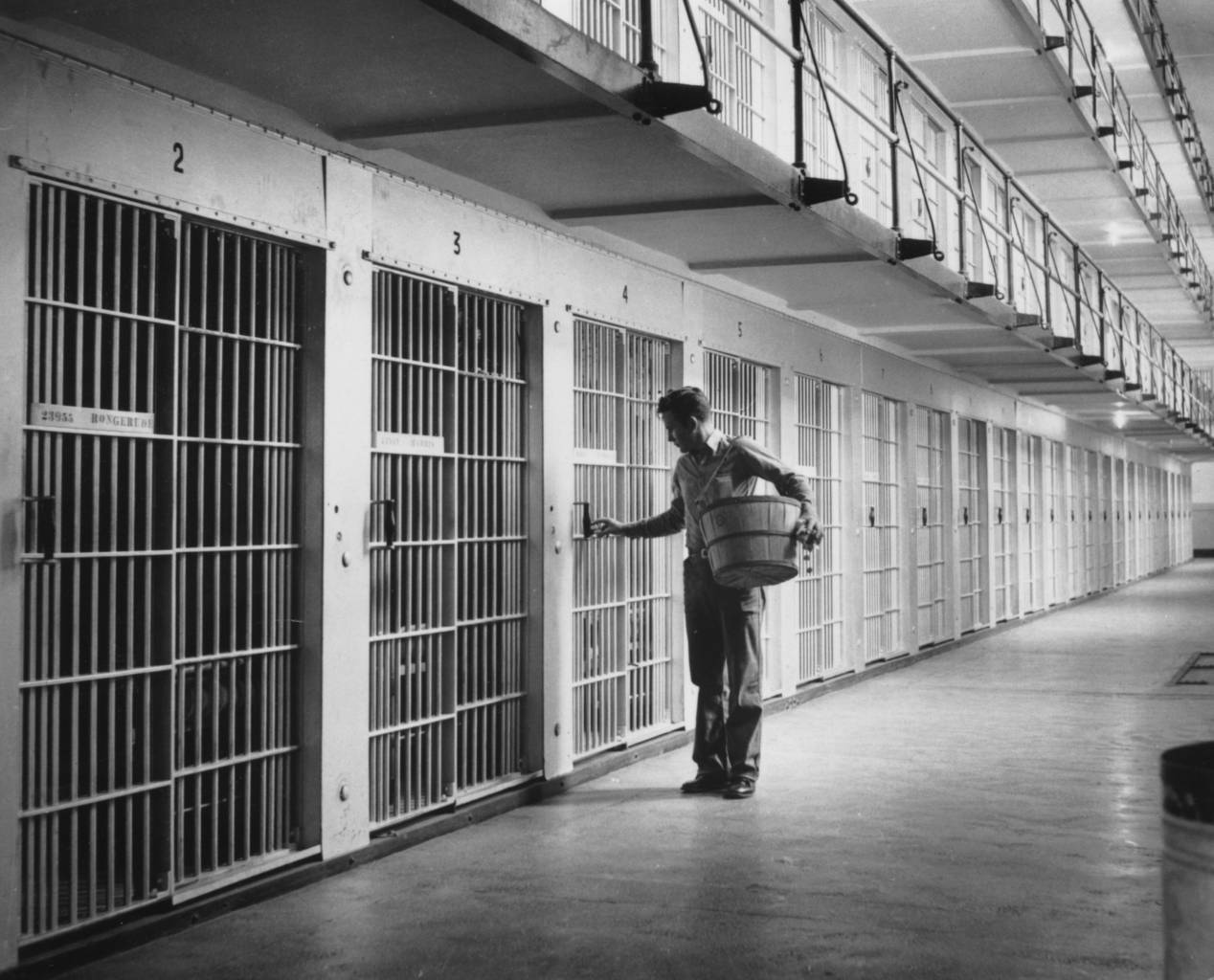 circa 1955: A prison warder delivering the weekly issue of matches to cells inside one of Iowa's four prison cell houses, islands of steel and concrete set in huge buildings with walls up to 8ft thick. (Photo by Three Lions/Getty Images)