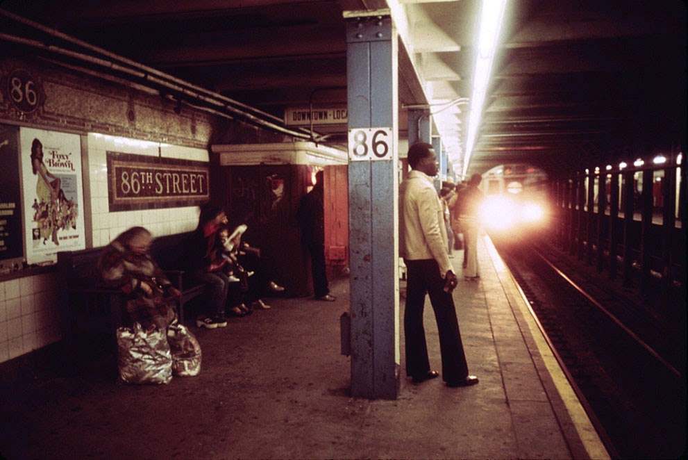Passengers wait for a Lexington Avenue Line subway train on one of the platforms of the New York City Transit Authority, April, 1974. (Jim Pickerell/NARA)
