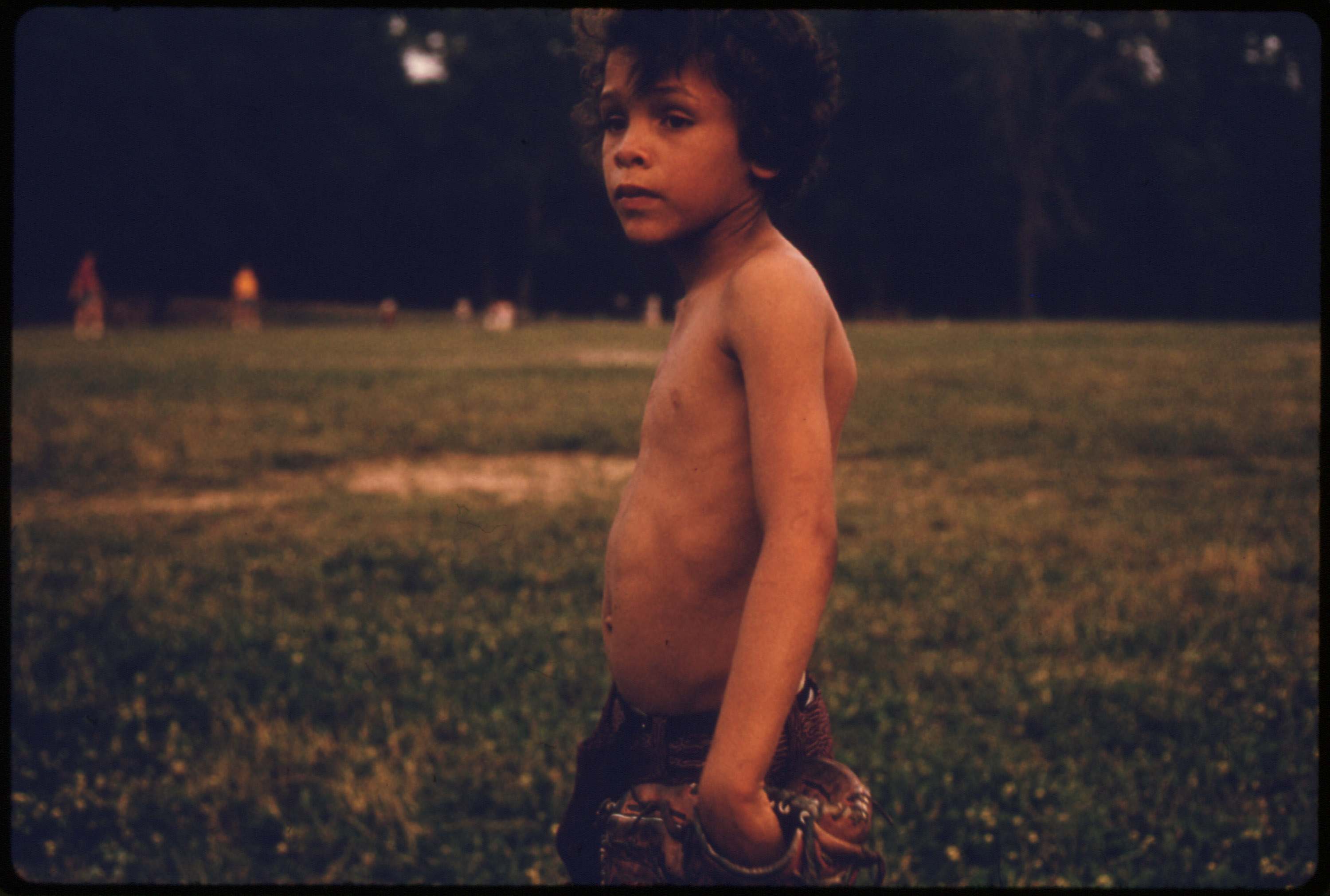 Puerto-Rican boy playing softball in Brooklyn's Hiland Park, July 1974.