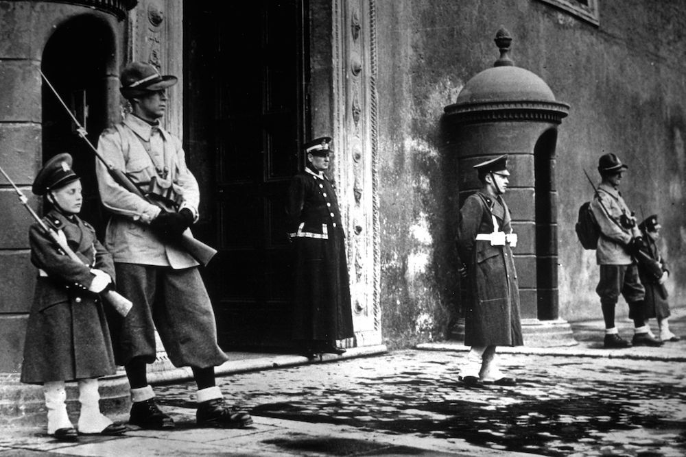 circa 1939: A child 'sentry' standing outside the Palazzo Venezia, alongside older sentries. (Photo by Topical Press Agency/Getty Images)