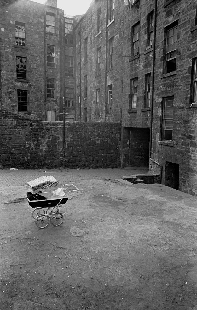 Baby in pram tenement courtyard, Maryhill 1971