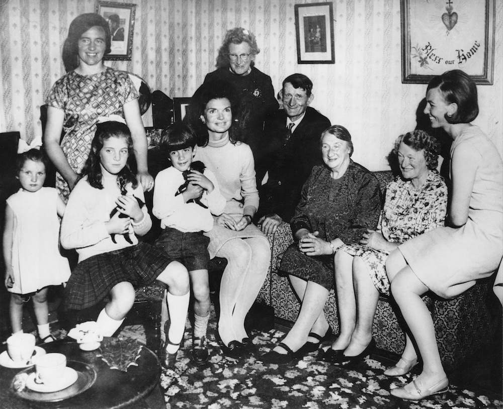 Jacqueline Kennedy (1929 - 1994) with her children Caroline and John in the living room of the Kennedy ancestral home at Dunganstown, County Wexford, during a family holiday in Ireland, 29th June 1967. In the family group is Mary Ryan, the late President's cousin, along with relations Maeve Rowe, Josie Grennan (Mrs Ryan's granddaughter), Mrs John Fenlon, James Kennedy (Mrs Ryan's brother), Margaret Kirwan (Mrs Ryan's sister), and Miss Mary Ryan (Mrs Ryan's daughter). (Photo by London Central Press/Hulton Archive/Getty Images)