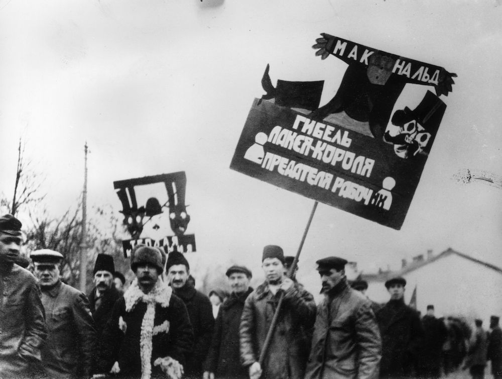 7th November 1924:  A banner being carried by workers during a procession in Moscow celebrating the 7th anniversary of the Bolshevist Revolution depicts the political death of Ramsay MacDonald.  (Photo by Topical Press Agency/Getty Images)