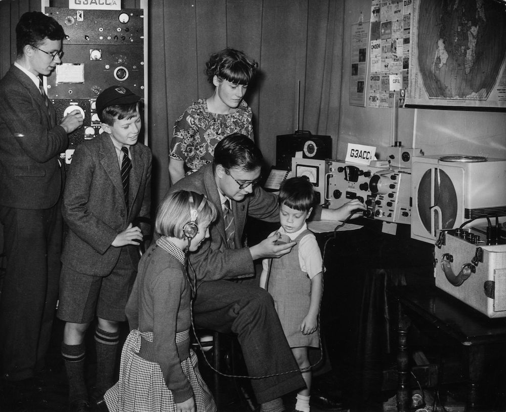 7th September 1951:  An amateur radio station G3ACC/A at Camberwell Council's Festival of Britain exhibition attracts young visitors. Malcolm Thayer is the duty officer encouraging a young enthusiast to send a message across the world.  (Photo by Fred Morley/Fox Photos/Getty Images)