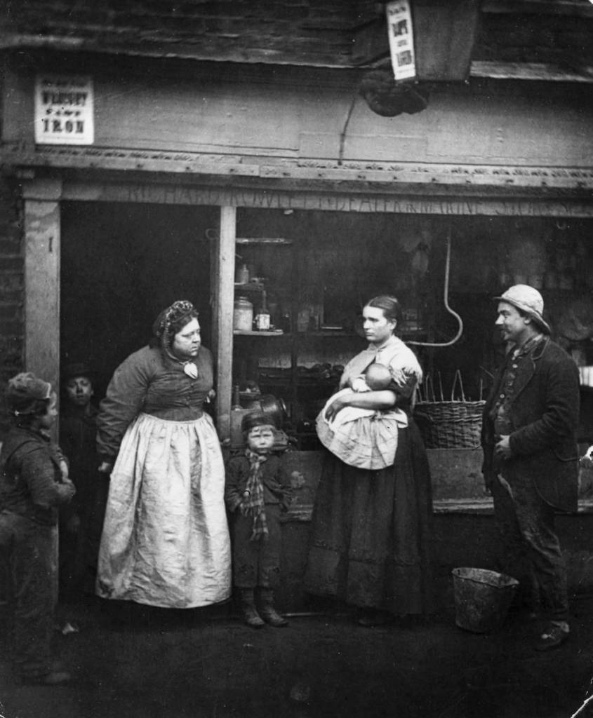 circa 1877: Impoverished people in front of a rag shop in Lambeth, London, where the Thames annual tidal overflow causes hardship to the locals. 'Sufferers From The Floods', a photographic plate from 'Street Life In London' by Smith and Thomson (pub. 1877). (Photo by John Thomson/Hulton Archive/Getty Images)