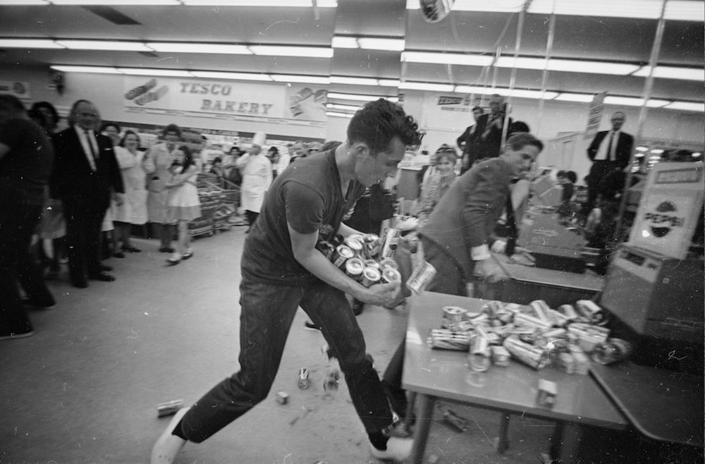10th August 1966: Joe Buzidragis, whose parents won a US supermarket sweep contest helps them repeat their prize-winning feat in a London Tesco. (Photo by Terry Fincher/Express/Getty Images)