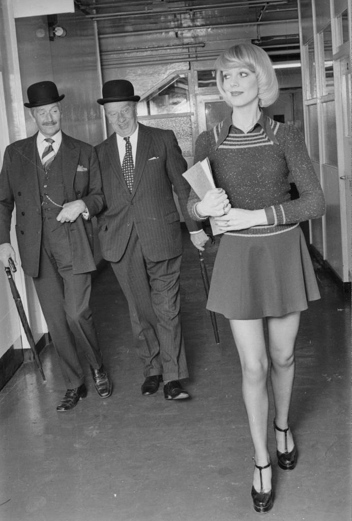 7th June 1974:  Two suited businessmen enjoy the sight of an attractive young secretary in a mini skirt.  (Photo by M. McKeown/Express/Getty Images)