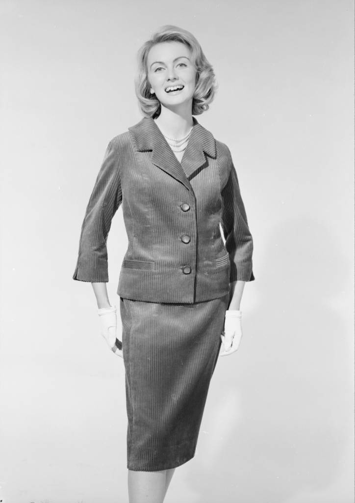 22nd June 1960: A sixties fashion model wearing a button-through jacket and matching pencil skirt for sale at John Barkers department store in London. (Photo by Chaloner Woods/Getty Images)