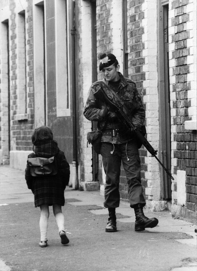 13th May 1981: A Belfast girl chats to a soldier out patrolling the streets in the Falls Road area. (Photo by Central Press/Getty Images)