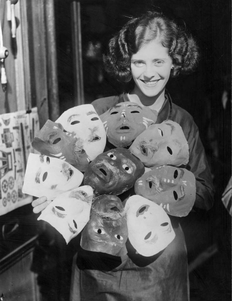 27th October 1934: An assistant at a shop in Slough, Berkshire, with a selection of Guy Fawkes masks. (Photo by William Vanderson/Fox Photos/Getty Images)