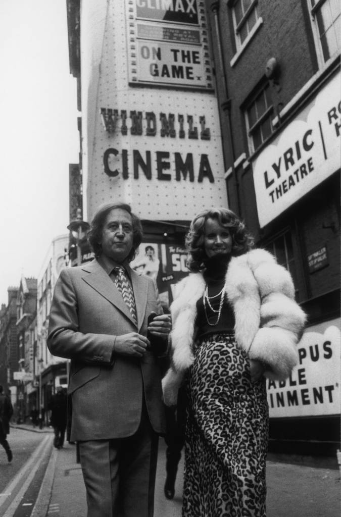 British nightclub owner and publisher Paul Raymond (1925 - 2008) with his girlfriend, actress and glamour model Fiona Richmond outside the Windmill Cinema in London's Soho, 18th February 1974. Raymond has just bought the theatre as a venue for his nude revues. (Photo by Keystone/Hulton Archive/Getty Images)