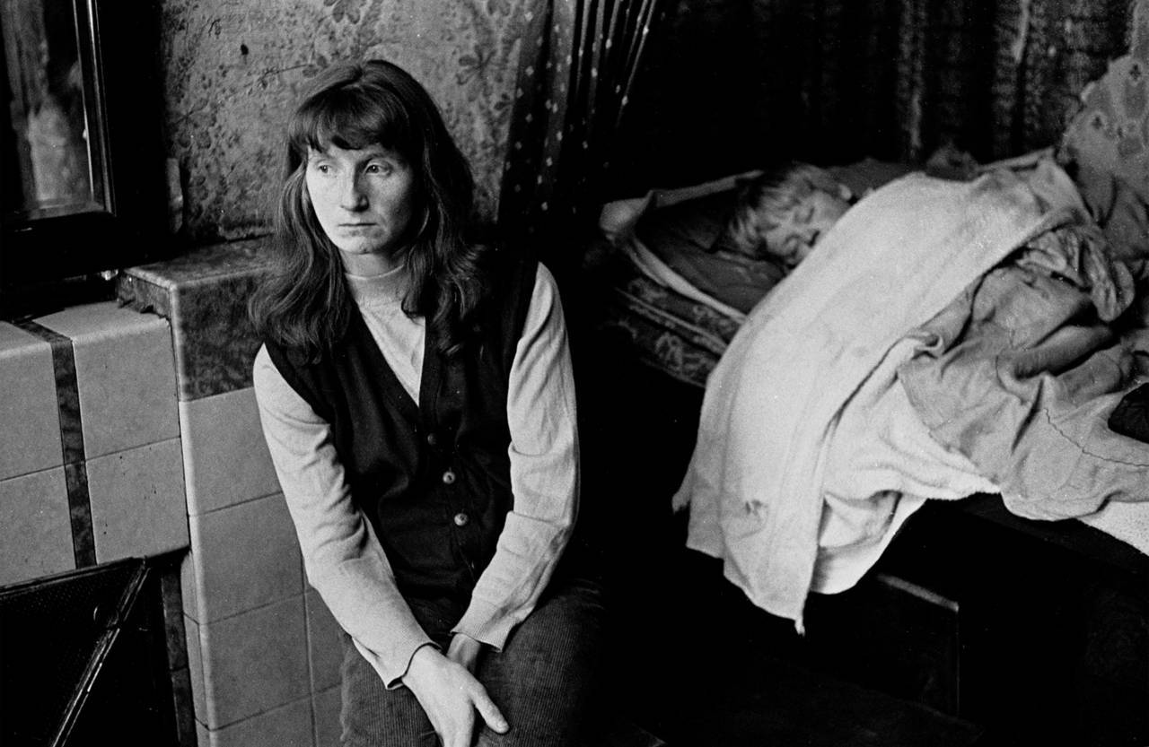 Mother with her sleeping child living in a single end tenement flat Glasgow 1971