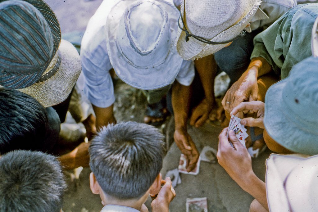 Local men take a mid-day break for a little card game. In northeast My Tho in 1969. (Dinh Tuong Province in the Mekong Delta of Vietnam) (scanned colour slide)