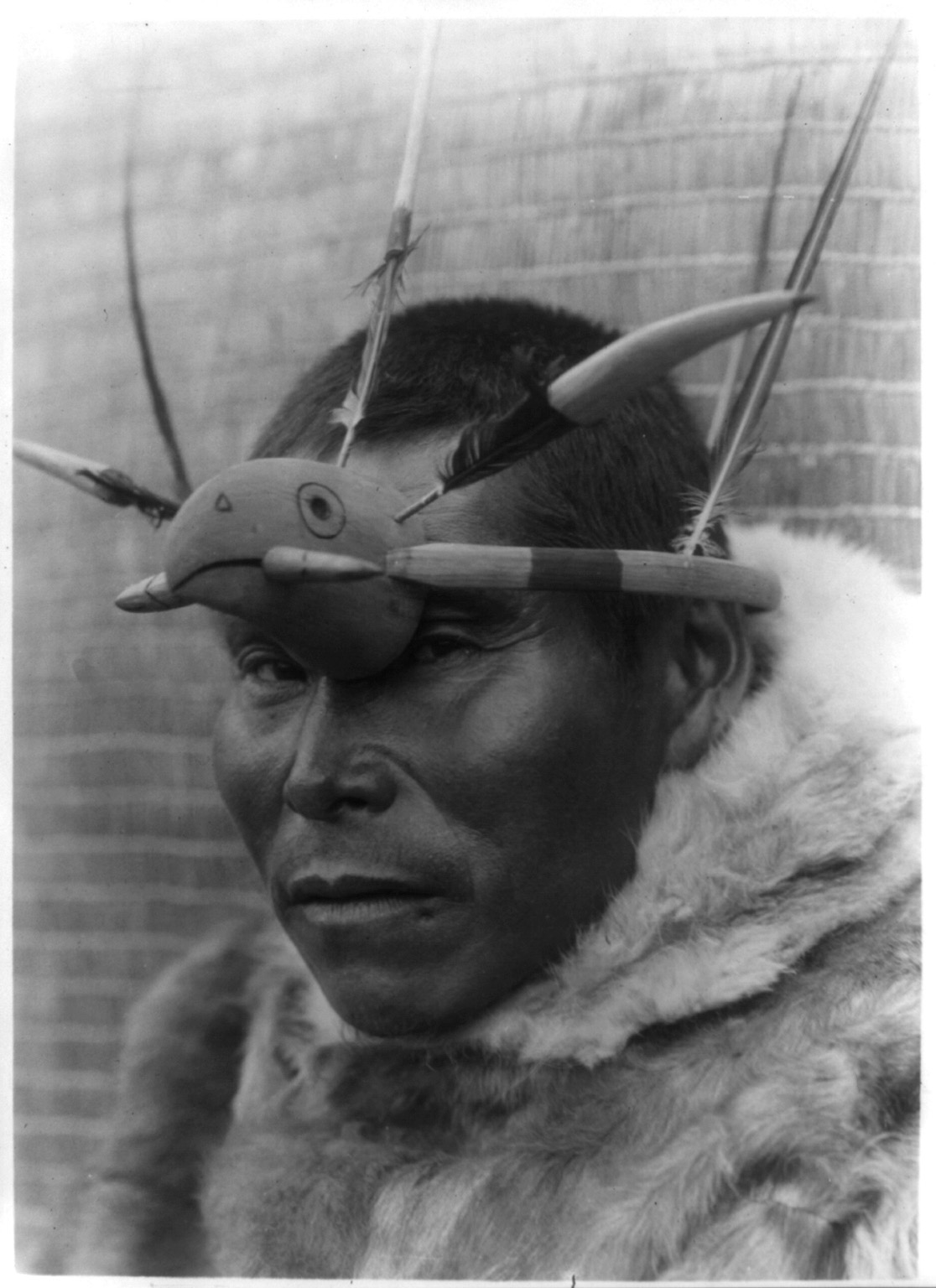 Title Maskette--Nunivak Summary Eskimo man, head-and-shoulders portrait, wearing headdress consisting of a protruding headband around the crown of his head, feathers, and a wooden bird head in front. Contributor Names Curtis, Edward S., 1868-1952, photographer Created / Published c1929 February 28.