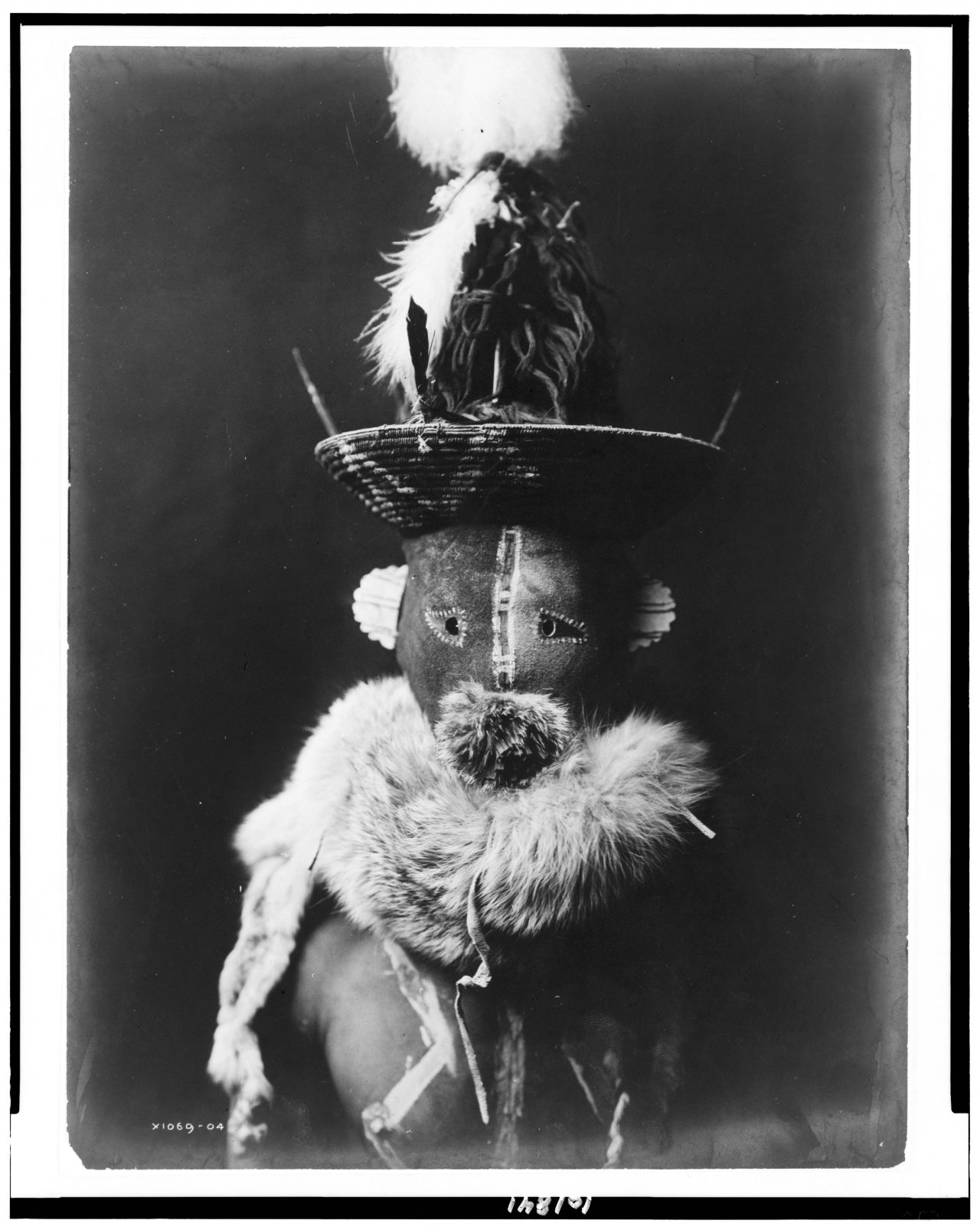 Title [Zahadolzha--Navaho] Summary Indian, head-and-shoulders portrait, facing front, wearing leather mask with basket cap, fur ruff, nude torso painted with white lines. Contributor Names Curtis, Edward S., 1868-1952, photographer Created / Published 1904, c1905.