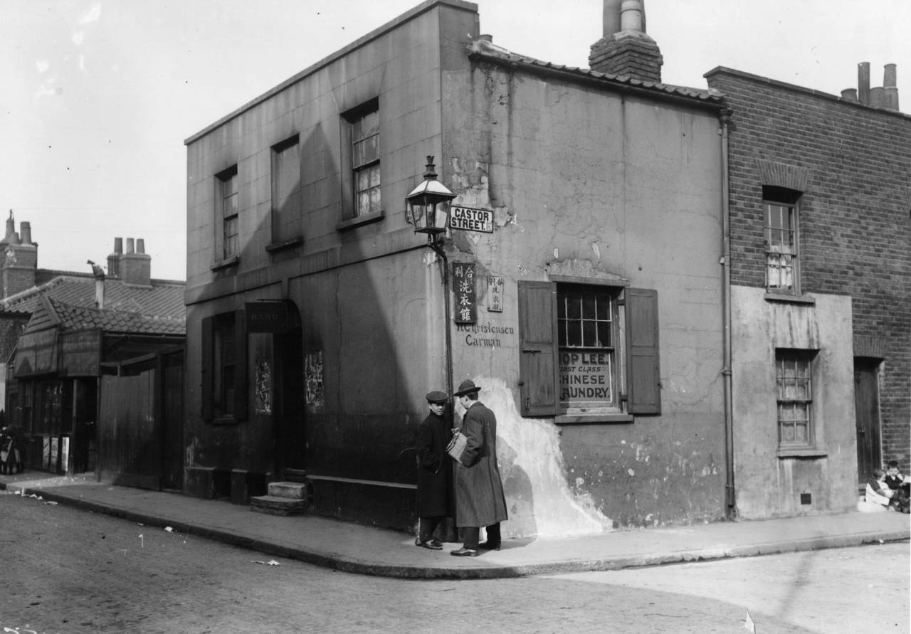 Two Chinese men meet on a street corner in China Town in London's East End. (Photo by Topical Press Agency/Getty Images)