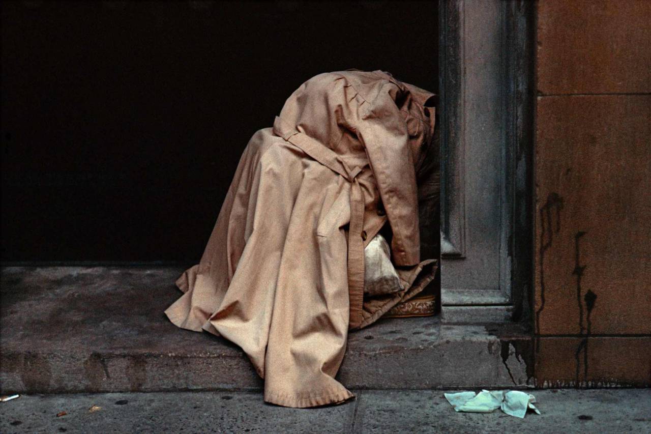 1984, New York, homeless person under raincoat